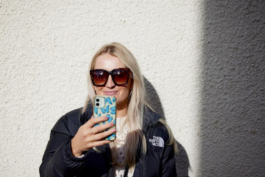 A student takes a selfie with a mobile phone