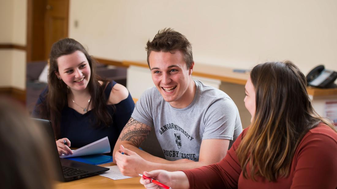 Myfyrwyr yn rhanny jôc yn ystod seminar