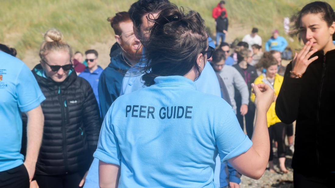 Peer guides helping students on a welcome week activity at the beach