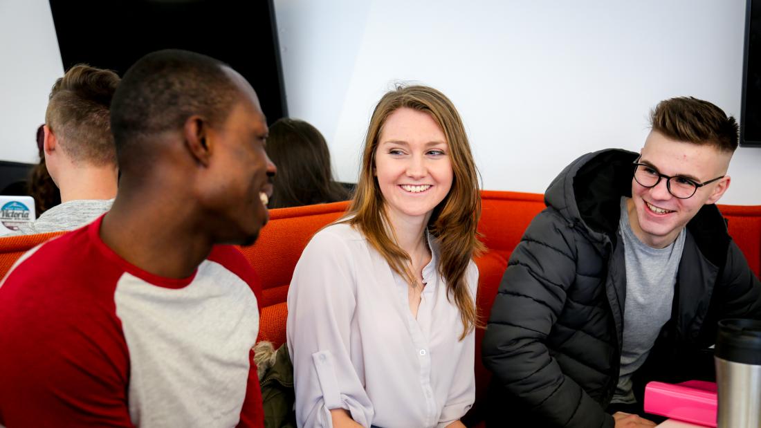 Friends doing group work together in a shared learning space, in Pontio