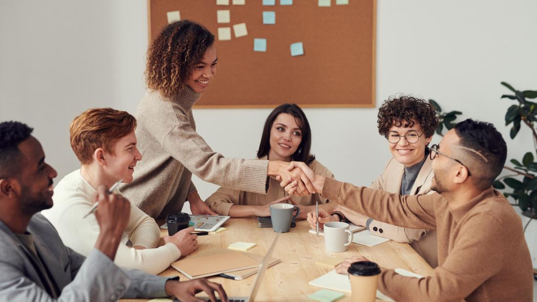 group of people meeting  in an office, in a happy setting