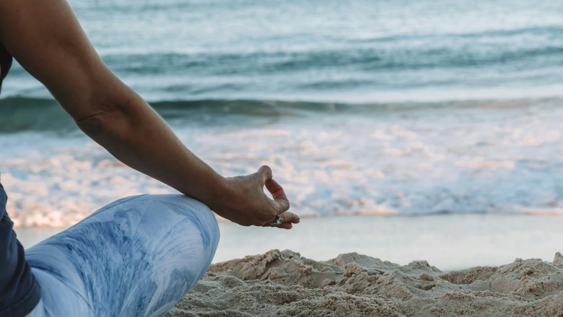 Person sitting down in a meditating position