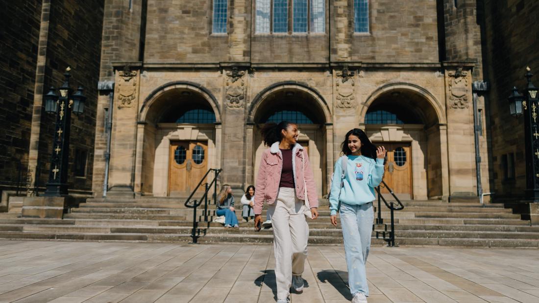 Two students walking in the quad 