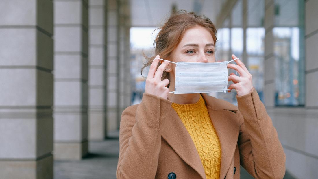 Woman putting on facemask