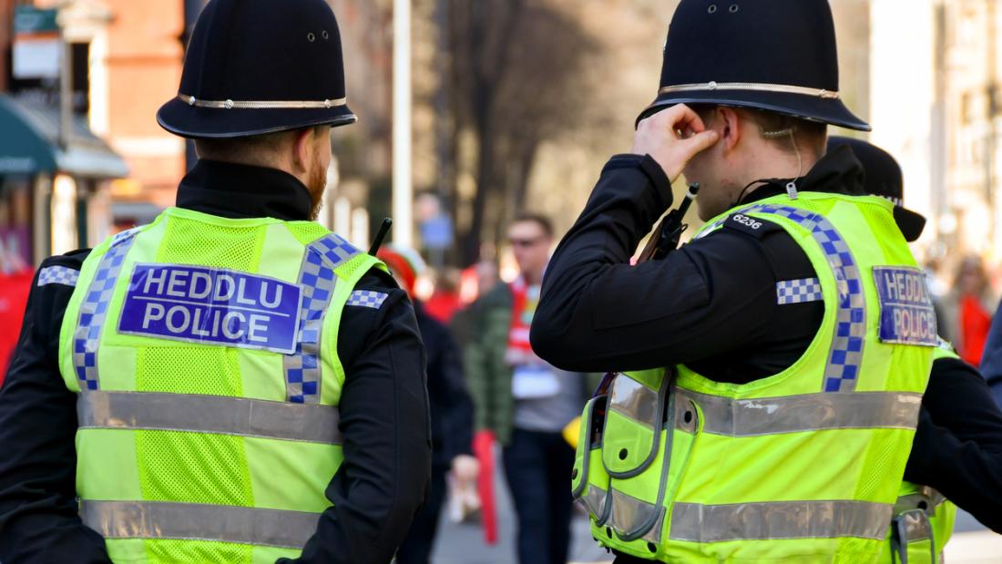 Cardiff, Wales - March 2022: Rear view of two police officers on duty in Cardiff city centre