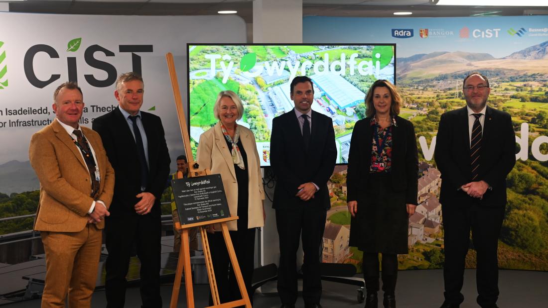 6 people standing in behind a plaque for the ppening ceremony of Ty Gwyrddfai 