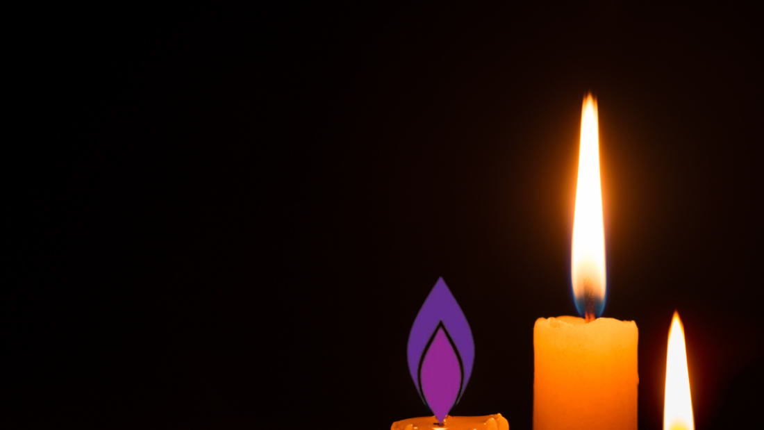 Picture of candles with the Holocaust memorial logo