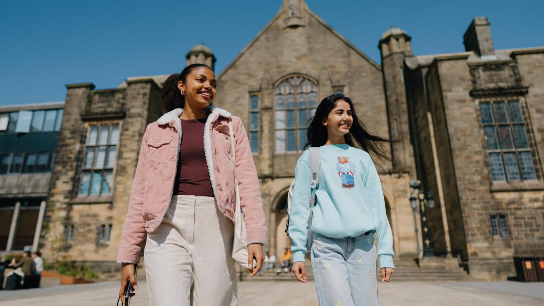 Two students walking away from the Main Arts Building 