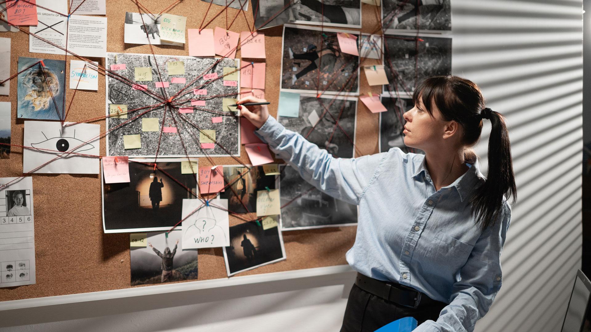 criminal investigator collating information on a pin board