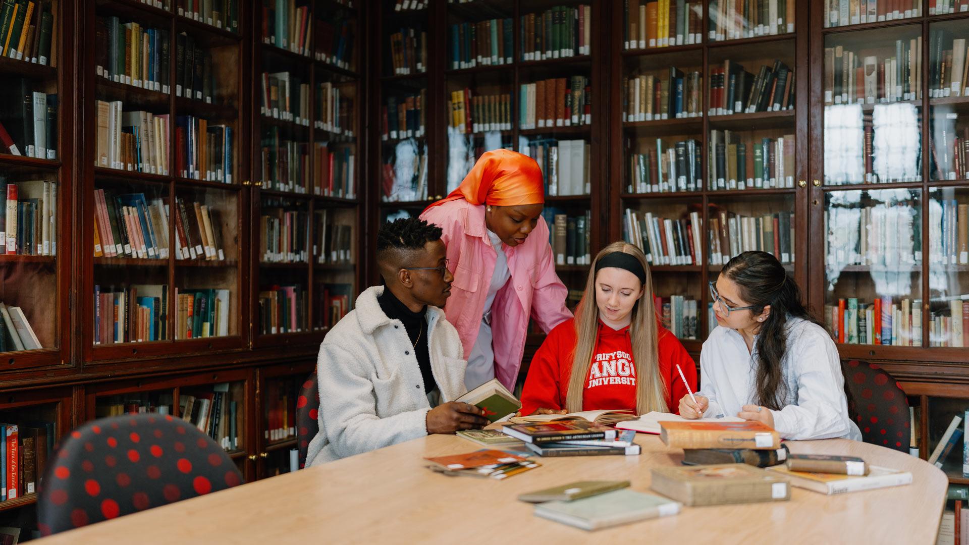 Students looking at history books in library