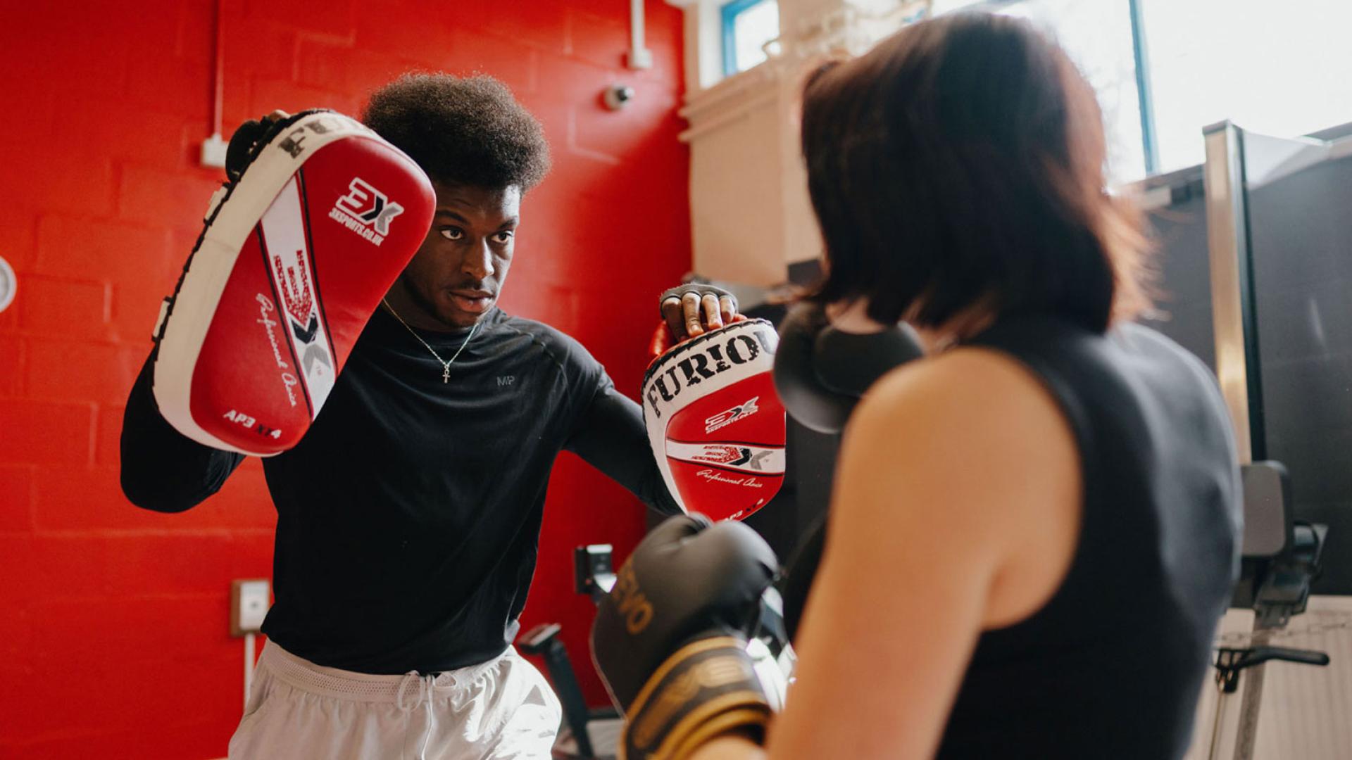 Boxing with coach in gym