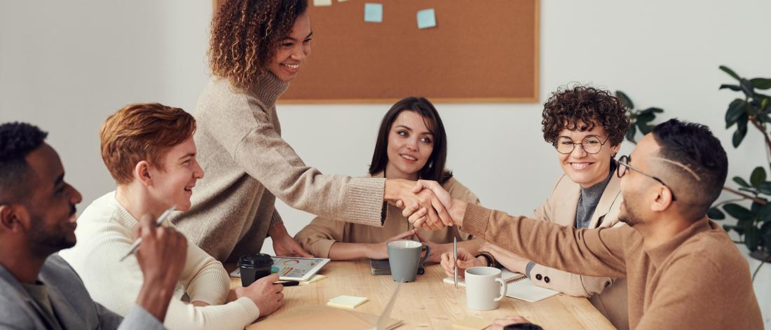 group of people meeting  in an office, in a happy setting