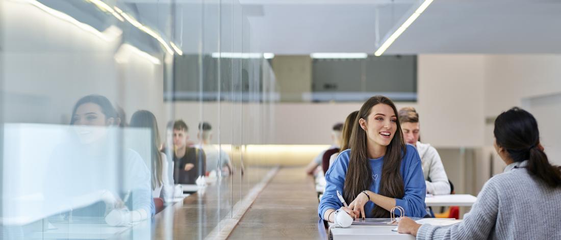 Image of a group of students sitting by a table at the Pontio learning space