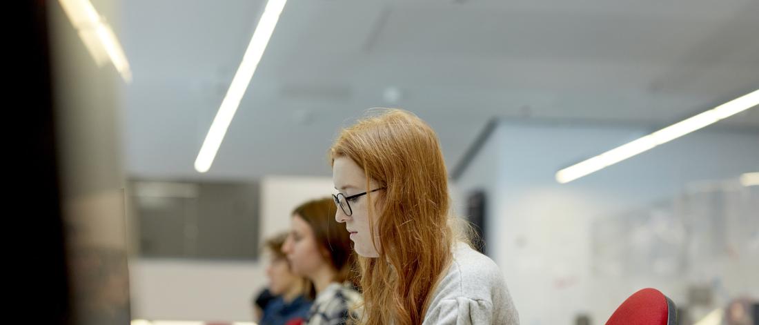 Students in a study room, working on computers