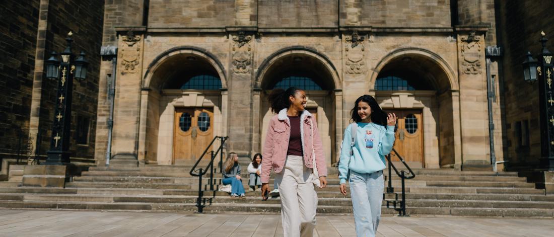 Two students walking in the quad 