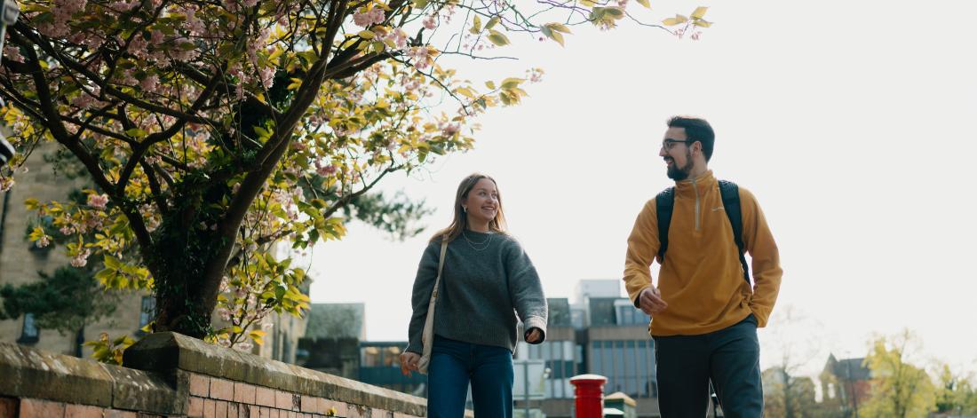 Two students walking outside the main university building