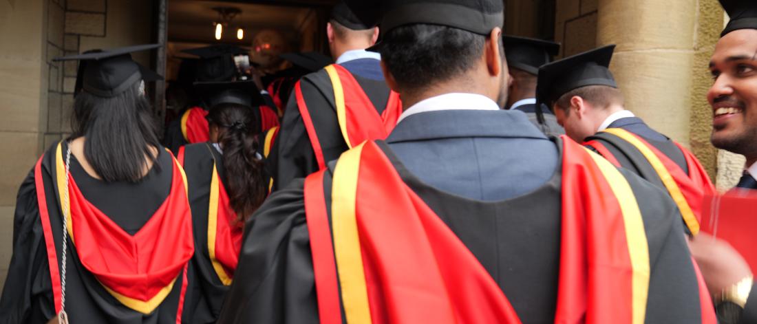 Students walking into hall in their graduation cap and gown