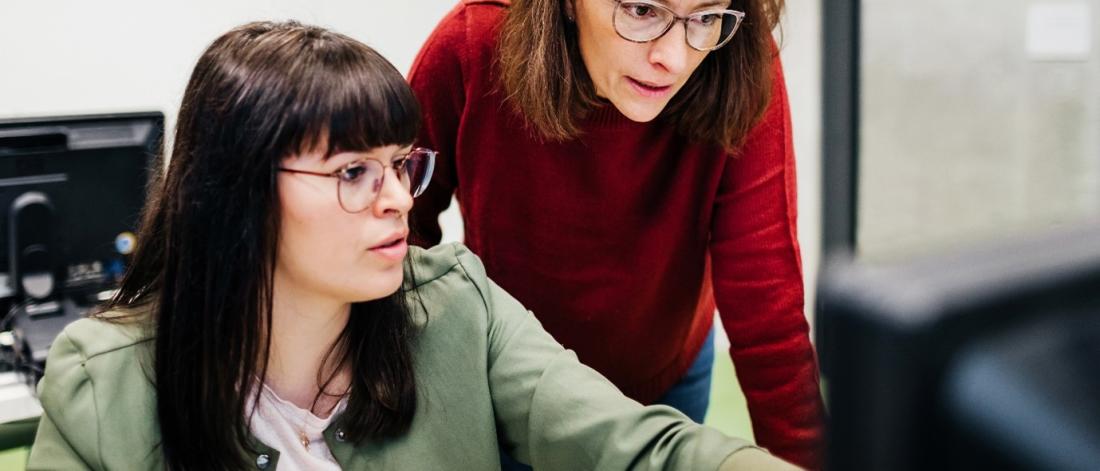 2 people working on a computer.