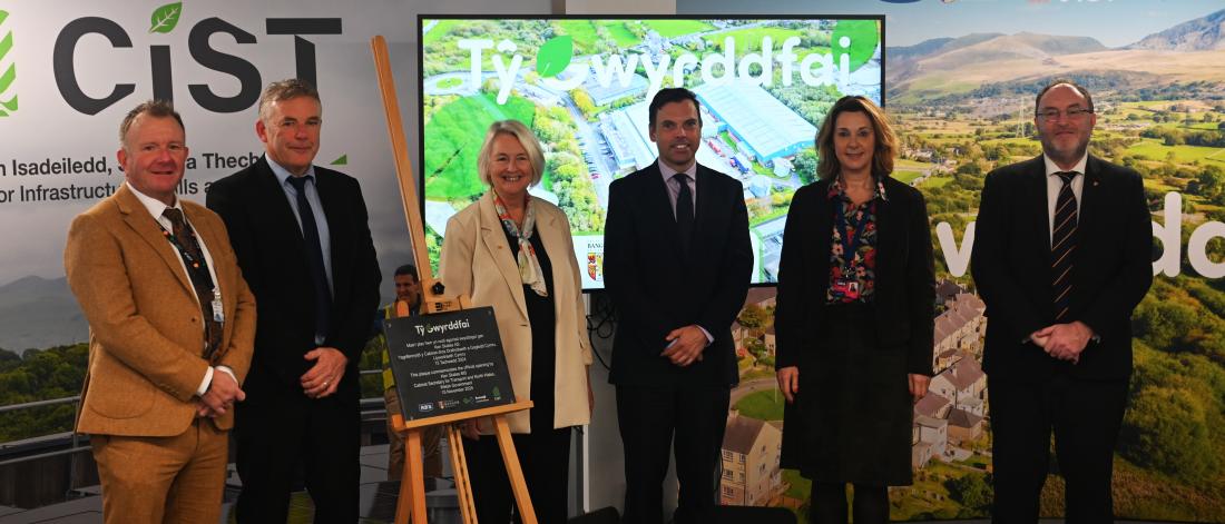 6 people standing in behind a plaque for the ppening ceremony of Ty Gwyrddfai 