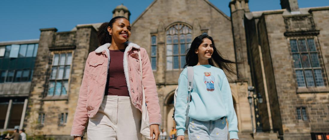 Two students walking away from the Main Arts Building 