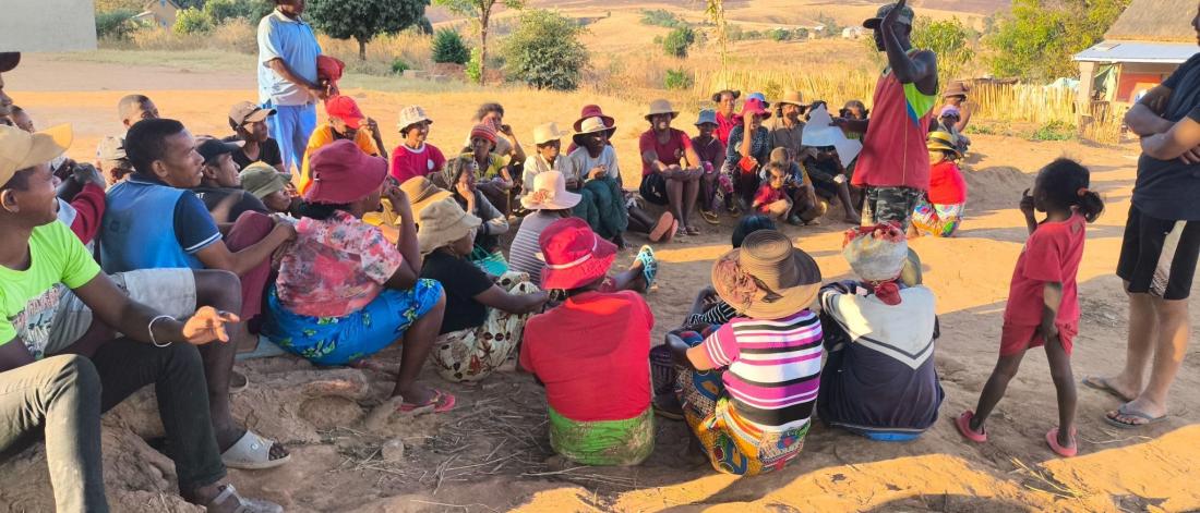 Group of people siting outside in Madagascar discussing 