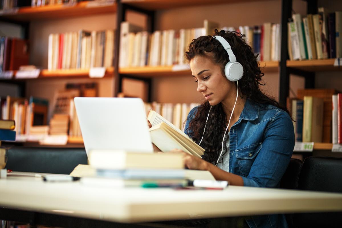 Listening library. Человек в наушниках. Наушники в библиотеке. Девушка в наушниках. Девочка в наушниках в библиотеке.