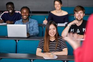 A group of students smiling during a lecture