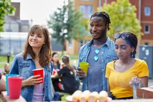 Students socialising outside halls of residence at Ffriddoedd Student Village