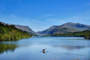 Myfyriwr mewn caiac ar Lyn Padarn yn Llanberis