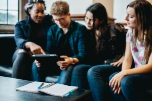 Students socialising on a sofa in the Main Arts building