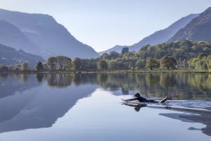 Myfyriwr ar Fwrdd Padlo ar Llyn Padarn yn Llanberis