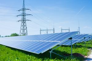 Solar panel next to high voltage towers