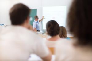 A lecturer pointing to a whiteboard