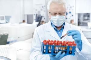 Scientist wearing protective mask working with blood samples in a laboratory