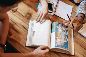 students looking at book