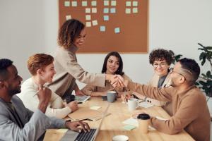 group of people meeting  in an office, in a happy setting