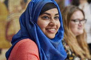 Female student with blue headscarf, smiling