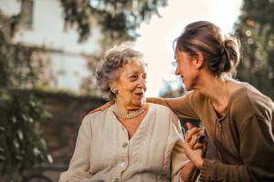 Image of two woman, older and younger, holding hands evoking emotional and support