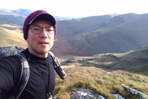 Image of member of research staff, Leejiah Doorward, with mountains in the background