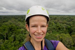 Woman in hard hat with greenery around her