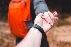 Two people holding hand- symbolising helping hand