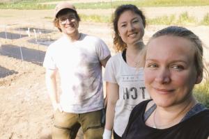 Three researchers in the field setting up plastic mulch film trials