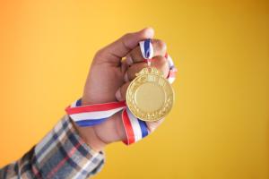 Hand holding gold medal