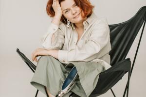 A Woman With Prosthetic Leg Sitting on a Folding Chair