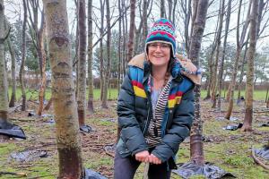 Kara Marsden digging in the outdoors with trees in the background