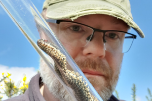 Dr Axel Barlow holding a snake