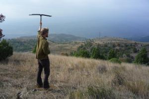 Dr Peter Haswell standing on a grassy hillside holding an aerial