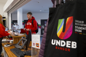 A student talking with a member of staff at the Undeb Bangor reception