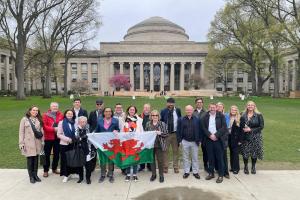 A group of people holding a Welsh flag in front of the Massachusetts Institute of Technology