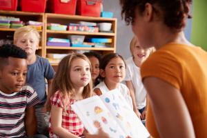 Group of primary school children sat listening to the teacher in a classroom